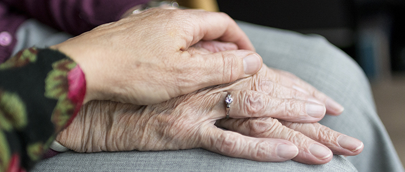 Image of a younger person's hand clasping that of an older persons