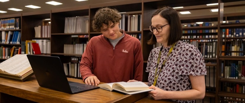 librarian helping student with book