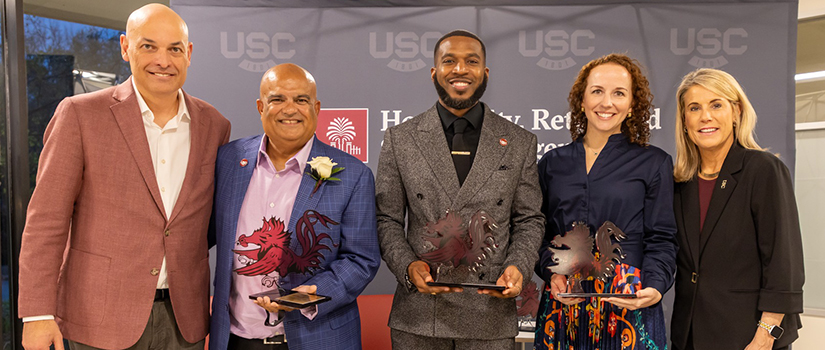 Winners of the HRSM Alumni Awards display their awards.