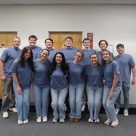 Members of Sigma Psi Mu pose inside the Close-Hipp Building