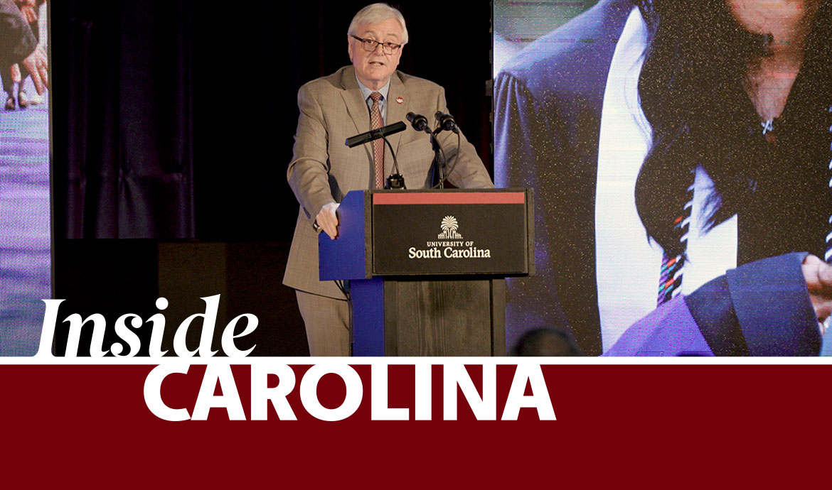 graphic that has a frame with the words Inside Carolina over an image of a man in a suit speaking at a podium with images on screens behind him
