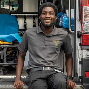 Tremayne Ansani sits on the tailgate of an ambulance.