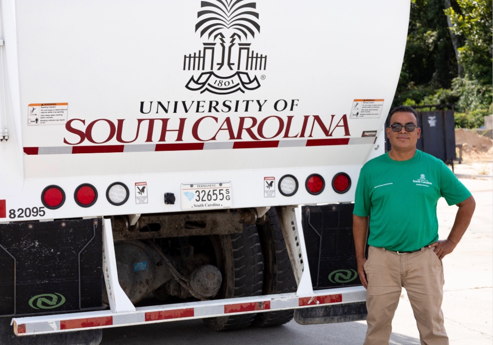 Tony Castro stands in front of the USC trash truck that he drives daily for his job.